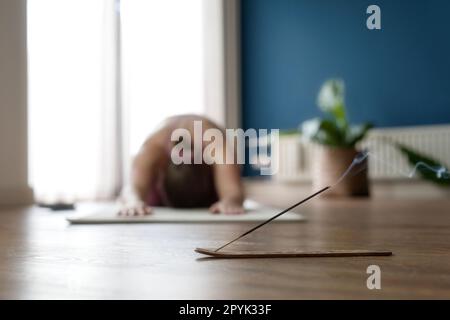 Junge Frau, die zu Hause Yoga praktiziert, Kopierraum. Mädchen entspannen Meditation in Kinderhaltung, volle Länge. Entspannen und Yoga machen, sich ausruhen, dehnen. Wellness und gesunder Lebensstil. Balasana Stockfoto