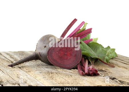 Rote Bete mit grünen Blättern auf grauem rustikalem Holz Stockfoto