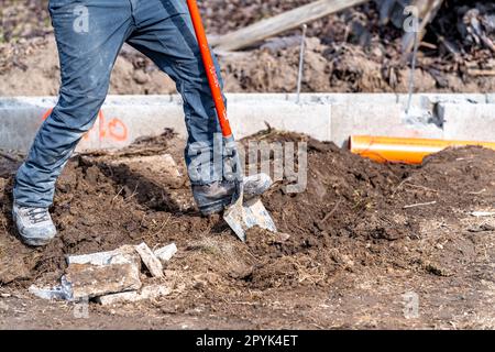 Graben im Boden für Kunststoffrohre für Wasser und Abfall. Stockfoto