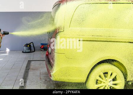 Die Autos in der Garage mit grünem Aktivschaum waschen Stockfoto