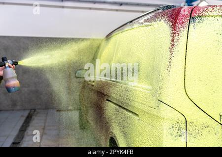 Die Autos in der Garage mit grünem Aktivschaum waschen Stockfoto