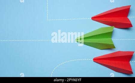 Drei Papierflugzeuge bewegen sich vorwärts, einer seitlich, und repräsentiert das Konzept von Individualität und unkonventionellem Denken. Stockfoto