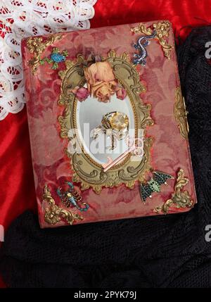 Antikes viktorianisches Buch mit farbenfrohen Edelsteinen. Märchenhaftes Buch mit Skorpion und Fledermaus Stockfoto