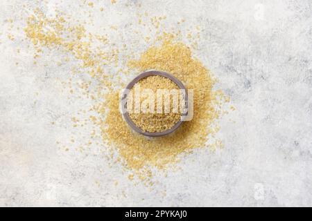 Holzschüssel mit Draufsicht auf trockenen, ungekochten Weizenkörner. Gesundes Essen Stockfoto