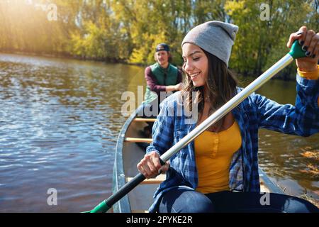 Als Paar neue Dinge ausprobieren. Ein junges Paar, das eine Kanufahrt auf dem See macht. Stockfoto