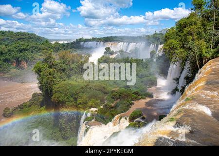 Malerischer Blick vom Gipfel der Wasserfälle mit einem Regenbogen zum Fluss Iguazu und San Martin Island, Iguazu Falls, Argentinien Stockfoto