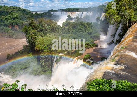 Malerischer Blick vom Gipfel der Wasserfälle mit einem Regenbogen zum Fluss Iguazu und San Martin Island, Iguazu Falls, Argentinien Stockfoto