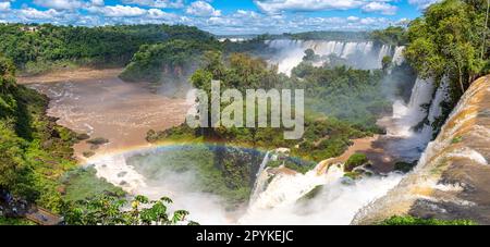 Panoramablick von der Spitze der Wasserfälle mit einem Regenbogen auf den Fluss Iguazu und San Martin Island, Iguazu Falls, Argentinien Stockfoto