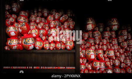 Ein Regal mit Daruma-Puppen, in Osakas Katusoji-Tempel. Stockfoto