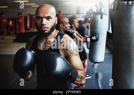 Wenn das Leben hart wird, zieh deine Boxhandschuhe an. Ein Boxertraining für Männer im Fitnessstudio. Stockfoto