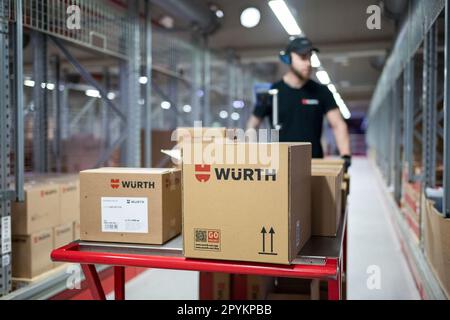 04. Mai 2023, Baden-Württemberg, Künzelsau: Ein Mitarbeiter der Würth Gruppe schiebt einen Kommissionierwagen durch einen Gang in der Logistikabteilung. Die Würth-Gruppe legt ihre Jahresabschlüsse auf einer Pressekonferenz vor und gibt einen Ausblick für das laufende Geschäftsjahr. Foto: Marijan Murat/dpa Stockfoto