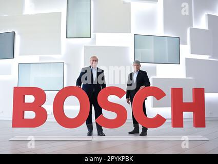 04. Mai 2023, Baden-Württemberg, Renningen: Die Vorstandsmitglieder der Bosch Technologiegruppe Stefan Hartung (l) (Vorsitzender) und Markus Forschner (Finanzen) stehen vor der jährlichen Pressekonferenz vor einem Bosch Logo. Am 4. Mai gibt Bosch seine Geschäftszahlen auf einer jährlichen Pressekonferenz bekannt. Foto: Bernd Weißbrod/dpa Stockfoto