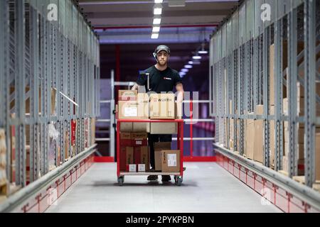 04. Mai 2023, Baden-Württemberg, Künzelsau: Ein Mitarbeiter der Würth Gruppe schiebt einen Kommissionierwagen durch einen Gang in der Logistikabteilung. Die Würth-Gruppe legt ihre Jahresabschlüsse auf einer Pressekonferenz vor und gibt einen Ausblick für das laufende Geschäftsjahr. Foto: Marijan Murat/dpa Stockfoto