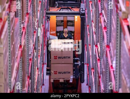 04. Mai 2023, Baden-Württemberg, Künzelsau: Ein Mitarbeiter der Würth Gruppe trägt eine Palette auf einem Gabelstapler in einem Gang eines Hochregallagers. Die Würth-Gruppe legt ihre Jahresabschlüsse auf einer Pressekonferenz vor und gibt einen Ausblick für das laufende Geschäftsjahr. Foto: Marijan Murat/dpa Stockfoto
