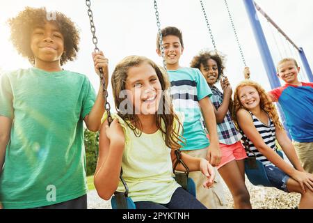 Kinder wollen nur Spaß haben. Eine Gruppe kleiner Kinder, die im Park zusammen spielen. Stockfoto