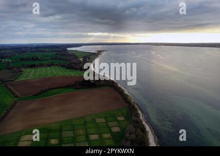 Panoramablick auf die Meeresküste aus der Luft während eines bewölkten Tages. Luftaufnahmen mit einer Drohne von einem Strand mit Vegetation und Felsen. Stockfoto