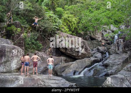 Teenager springen in ein Schwimmloch in Little Crystal Creek, Queensland, Australien Stockfoto