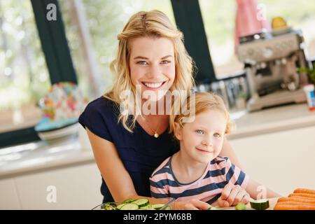 Mommys kleine Helferin. Porträt einer Mutter und Tochter, die zusammen zu Hause eine Mahlzeit zubereiten. Stockfoto