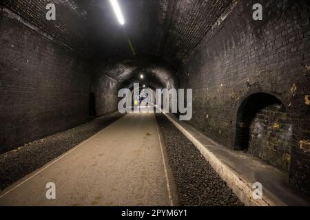 Radfahrer und Wanderer im Headstone Tunnel auf dem Monsal Trail, Peak District National Park, Derbyshire, England Stockfoto