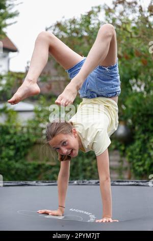 Ein junges Mädchen, das auf einem Trampolin spielt, Little Waltham, Essex, England