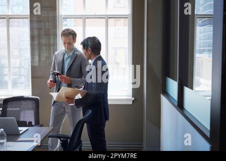 Diese Zahlen sehen gut aus. Geschäftsleute, die sich Papierkram in ihrem Büro ansehen. Stockfoto