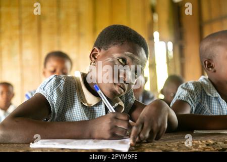 Ondo State, Nigeria - 2. Mai 2023 - Ein Schulmädchen, das seine Klassenarbeit mit Entschlossenheit an der Abereke-Schule in der Flussgemeinde von Ondo State schreibt Stockfoto