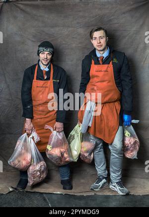 Zwei junge Metzger liefern Fleisch Stockfoto