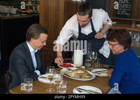 Der Kellner serviert Fisch im Brat Restaurant in London. Stockfoto