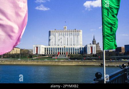 1988: Das Haus der Sowjets von Russland, kurz vor dem Maitag 1988. Das Gebäude wurde nach dem Putsch im August 1991 besser als das russische Weiße Haus bekannt und wurde 1993 während der russischen Verfassungskrise durch einen Panzerbrand schwer beschädigt, wurde aber seitdem wieder restauriert. Das barocke Gebäude im „Hochzeitstorten“-Stil im Hintergrund ist das Kudrinskaya Square Building, eine der so genannten „Sieben Schwestern“, die von Joseph Stalin als Teil eines Plans zur Modernisierung Moskaus unmittelbar nach dem Zweiten Weltkrieg in Auftrag gegeben wurde Eine weitere der Sieben Schwestern, das Hotel Ukraina, blickt auf das Weiße Haus auf der anderen Seite der Moskva. Stockfoto