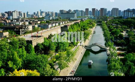 (230504) -- XI'AN, 4. Mai 2023 (Xinhua) -- Dieses Luftfoto wurde am 15. April 2023 aufgenommen und zeigt einen Blick auf einen malerischen Graben entlang der alten Stadtmauer in Xi'an, Nordwestchina der Provinz Shaanxi. XI'an, eine Stadt mit über 3.100 Jahren Geschichte, diente als Hauptstadt für 13 Dynastien in der chinesischen Geschichte. Es ist auch die Heimat der weltberühmten Terrakotta-Krieger, die in der Qin-Dynastie (221-207 v. Chr.) geschaffen wurden. In den letzten Jahren hat die Stadt innovative Veränderungen erforscht und dem historischen und kulturellen Erbe neue Vitalität verliehen. Touristen erhalten ein eindrucksvolles kulturelles Erlebnis durch ein Stockfoto