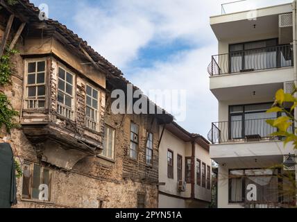 Antalya, Türkei - Dieses Foto zeigt den Kontrast zwischen dem traditionellen osmanischen Haus und dem modernen Apartmentgebäude in Kaleici, dem Stockfoto