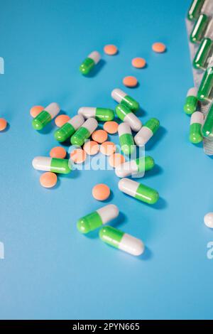 Verschiedene pharmazeutische Pillen, Tabletten und Kapseln auf blauem Hintergrund. Behandlungskonzept. Stockfoto