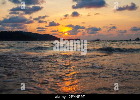 Unglaublich malerische Landschaft mit Blick auf die Wellen im Meer und die Bronzesonne zur goldenen Stunde bei Sonnenuntergang in thailand auf der Insel ph Stockfoto