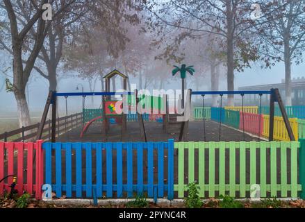 Nebliger Spielplatz in Vryssi Tyrnavou, ein malerischer kleiner See und ein schönes Erholungsgebiet in der Nähe von Tyrnavos Stadt, Larissa, Thessalien, Griechenland. Stockfoto