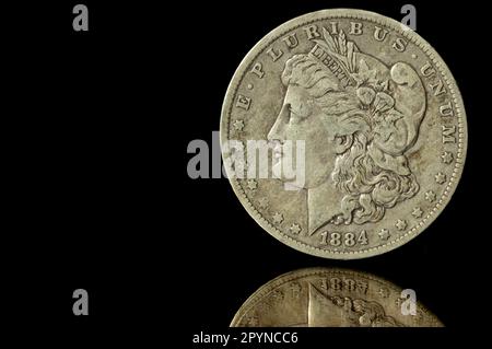 1884 Morgan Silver Dollar vor schwarzem Hintergrund mit Spiegelung Stockfoto