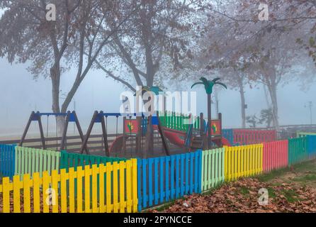 Nebliger Spielplatz in Vryssi Tyrnavou, ein malerischer kleiner See und ein schönes Erholungsgebiet in der Nähe von Tyrnavos Stadt, Larissa, Thessalien, Griechenland. Stockfoto