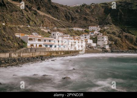 Ein großes Gewässer in der Nähe einiger weißer Gebäude auf dem Berg, La Gomera, Spanien, Kanarische Inseln Stockfoto