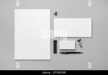 Leere Schreibwaren auf grauem Papierhintergrund. Vorlage für Branding-Design. Flach verlegt. Stockfoto