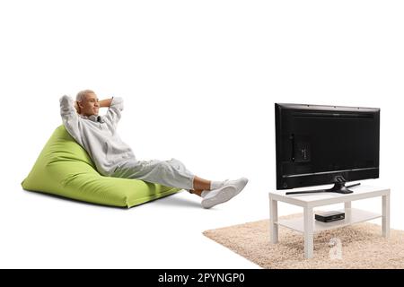 Ein afroamerikaner sitzt auf einem Sessel und sieht fern, isoliert auf weißem Hintergrund Stockfoto