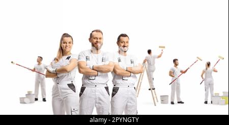 Ein Team professioneller Maler, die eine Wand auf weißem Hintergrund dekorieren Stockfoto