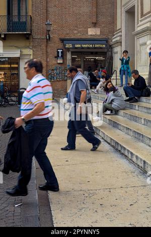 Geschäfte neben einer Treppe auf einem Platz, an dem Touristen vorbeikommen Stockfoto