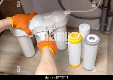 Der Installateur installiert oder wechselt den Wasserfilter. Ersatz-Aqua-Filter Stockfoto