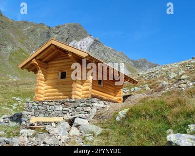 Kleine Almhütte/Schutzhütte aus Holz inmitten einer malerischen Bergszene Stockfoto