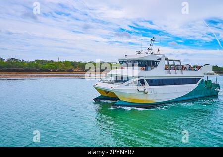 Die Passagierfähre schwimmt am grünen Ufer des Guadalete River entlang zum Terminal Station in El Puerto, Spanien Stockfoto