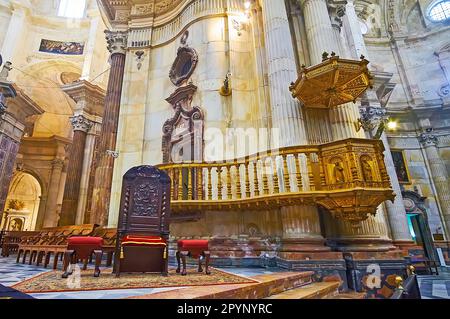 CADIZ, SPANIEN - 21. SEPTEMBER 2019: Die geschnitzte vergoldete Kanzel und der hölzerne Bischofshron in der Hauptkapelle (Capilla Mayor) der Kathedrale von Cadiz, am 21. September in C Stockfoto