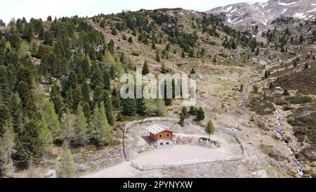 Kleine Almhütte/Schutzhütte aus Holz inmitten einer malerischen Bergszene Stockfoto