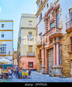 CADIZ, SPANIEN - 21. SEPTEMBER 2019: Das kleine Plazuela de San Martin mit der historischen Fassade des Casa del Amirante (Admiralshaus) und einem kleinen Restaurant im Freien, Stockfoto