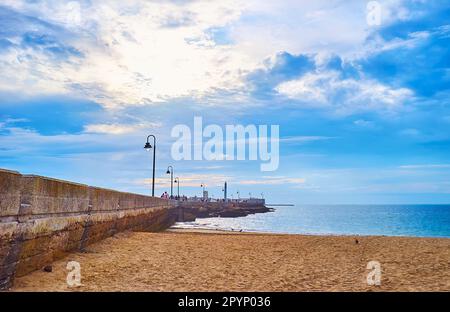 Der lange historische Steindeich der Burg San Sebastian vom Sandstrand La Caleta, Cadiz, Spanien Stockfoto