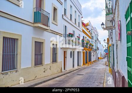 Die schmale Calle Cielos mit lebenden Häusern, dekoriert mit alten Laternen, Blumen in Töpfen, El Puerto, Spanien Stockfoto