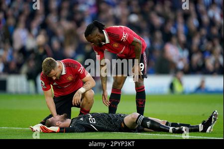 Der Torwart David de Gea von Manchester United wird von den Teamkollegen Luke Shaw (links) und Aaron Wan-Bissaka überprüft, nachdem er während des Spiels der Premier League im AMEX Stadium, Brighton, vom Ball ins Gesicht getroffen wurde. Foto: Donnerstag, 4. Mai 2023. Stockfoto